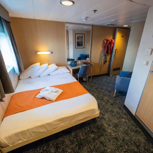 Double cabins (2) are slightly smaller than superior double cabins and have a double bed, two wardrobes, an armchair, writing desk and a private bathroom with shower and toilet. – Norwegian Adventure Company