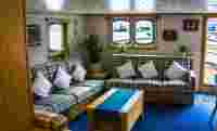 Lounge with bar and exit right to the aft deck. – Norwegian Adventure Company