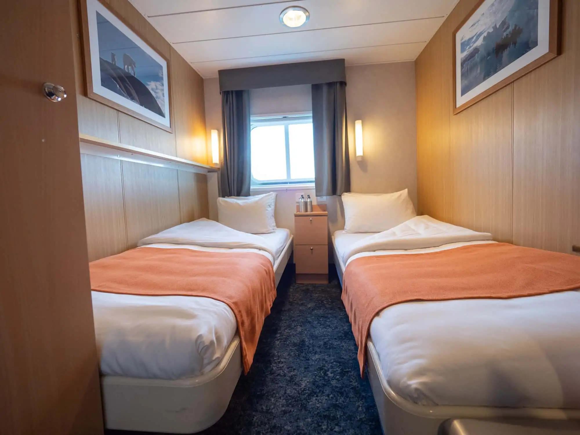 Twin cabins (4) have two single beds, a window, one wardrobe and are slightly smaller than twin cabins plus. Also with a private bathroom with shower and a toilet. – Norwegian Adventure Company