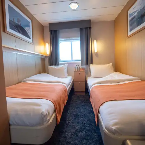 Twin cabins (4) have two single beds, a window, one wardrobe and are slightly smaller than twin cabins plus. Also with a private bathroom with shower and a toilet. – Norwegian Adventure Company