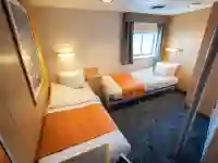 Twin cabins plus (12) have two single beds, a window, two small wardrobes and a private bathroom with shower and toilet. – Norwegian Adventure Company