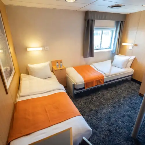 Twin cabins plus (12) have two single beds, a window, two small wardrobes and a private bathroom with shower and toilet. – Norwegian Adventure Company